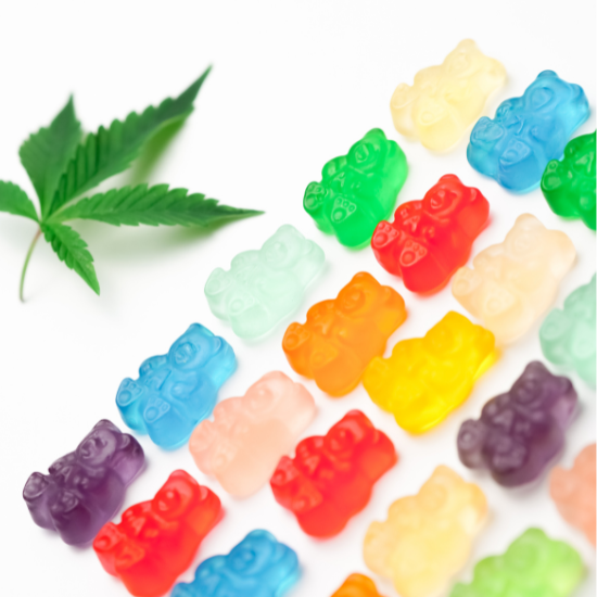 Colorful cannabis gummy bears with green marijuana leaf on white background for CBD edibles.